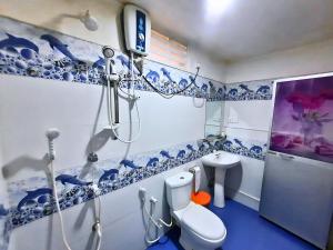 un bagno blu e bianco con servizi igienici e doccia di Batu's Safari lodge Udawalawe a Udawalawe