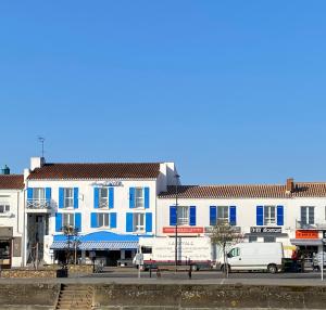 a blue and white building with a van parked in front at Atlantic Hôtel - L'Ile d'Yeu in L'Ile d'Yeu