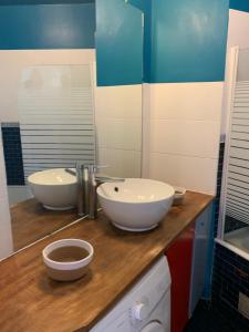 a bathroom with two sinks on a wooden counter at Paris La Défense - Santorin Apartment with jacuzzi in Courbevoie