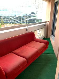 a red couch in a room with a large window at Paris La Défense - Santorin Apartment with jacuzzi in Courbevoie