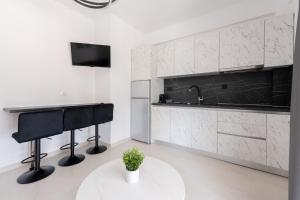 a white kitchen with a sink and a table at Central Square View Flogita in Flogita