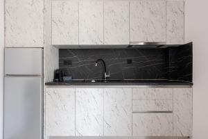 a kitchen with a sink and a refrigerator at Central Square View Flogita in Flogita