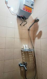 un bagno con doccia e tubo dell'acqua di Anjuma Backpacker a Yogyakarta