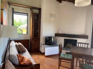 a living room with a couch and a table at Motta Verde con piscina e tennis in Brisino