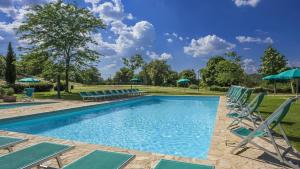 una piscina con tumbonas y sombrillas en Lavanda, en Gaiole in Chianti