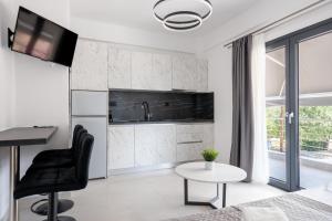 a white kitchen with a black chair and a table at Central Square View Flogita in Flogita