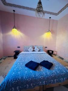 - une chambre avec un lit bleu et 2 oreillers dans l'établissement Hiking Nomads Guesthouse, à Tamellalt
