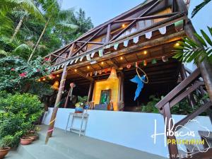 a small house with a blue wall in front of it at Hibiscus Prumirim Chalés in Ubatuba