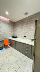 a kitchen with an orange chair in a room at شاليه ضي in Hail