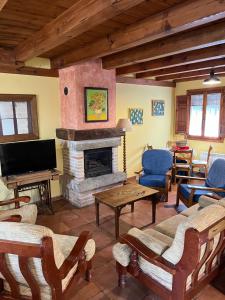 a living room with a fireplace and a tv at El Salegar in Roturas
