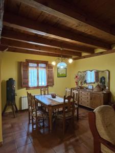 a dining room with a wooden table and chairs at El Salegar in Roturas