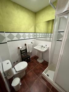 a bathroom with a toilet and a sink at El Salegar in Roturas +26 photos