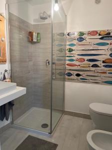 a bathroom with a shower with a glass shower stall at Agenzia Isotur ATTICO SUL PORTO in Ponza +3 photos