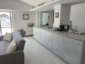 a living room with a couch and a kitchen at Agenzia Isotur ATTICO SUL PORTO in Ponza