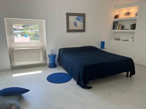 a bedroom with a blue bed and a window at Agenzia Isotur ATTICO SUL PORTO in Ponza