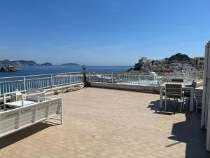 a patio with a table and chairs and the ocean at Agenzia Isotur ATTICO SUL PORTO in Ponza