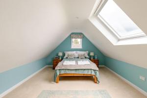 - une chambre mansardée avec un lit et une lucarne dans l'établissement Lovely Kent cottage with rural Medway views, à Tonbridge