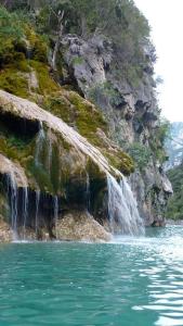 a waterfall on a mountain next to a body of water at Bulle de paix en Provence in Bras-dʼAsse