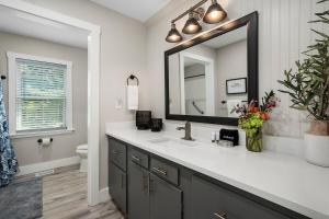 ein Badezimmer mit Waschbecken und Spiegel in der Unterkunft Hummingbird Haus - Sleeps 12 Cowboy Pool Firepit in Fredericksburg + 63 Fotos