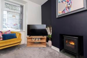 鲍内斯温德米尔Sheila's Cottage Bowness的带电视和壁炉的客厅