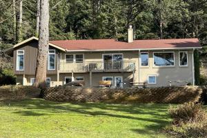 ein großes Haus mit einem Balkon und einem Baum in der Unterkunft Ocean Front, Eagle at the Oregon House, Stairs to the Beach! in Searose Beach