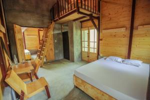 a bedroom with a bed and a chair in a cabin at Beverly Hill Cabanas Hikkaduwa in Hikkaduwa