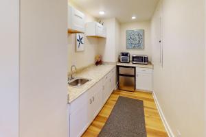 una cucina con mobili bianchi e un lavandino di Ocean Front Studio, Heron at Oregon House, Stairs to the Beach! a Searose Beach