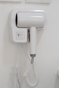 a white phone hanging on a wall with a cord at Bananaleaf Wedding Cafe & Resort in Ban Bang Kaeo