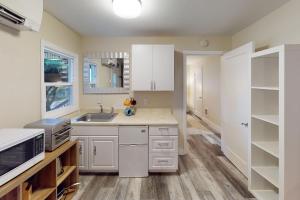 une cuisine avec des armoires blanches et un évier dans l'établissement Ocean Front, Sunset at Oregon House, Stairs to the Beach!, à Searose Beach 16 autres photos