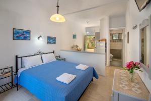 a bedroom with a blue bed and a kitchen at Soustas Apartments in Longós +86 photos