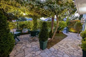 a patio with tables and chairs under a tree at Apartmani Bijelic HN in Herceg-Novi