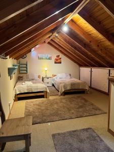 a room with two beds in a attic at El Foye in Villa La Angostura