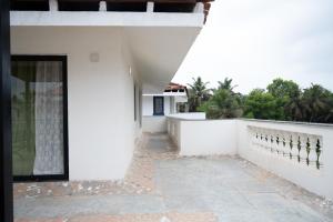 uma casa branca com uma porta e uma varanda em TERRA VERDE ! A Sunset Villa at Varca, South Goa ! em Varca