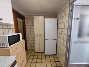 eine Küche mit Kühlschrank und Mikrowelle in der Unterkunft Apartamento en Playa de Bellreguard in Bellreguart