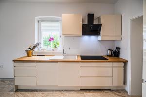 eine Küche mit weißen Schränken und einer Spüle und einem Fenster in der Unterkunft Holiday Home Evelin with Krka view in Cerklje ob Krki