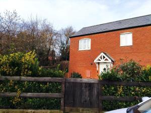 una casa de ladrillo rojo con una valla delante de ella en Garden House near shops in quiet location en Banbury
