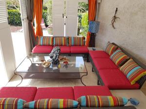 a living room with red couches and a glass table at Chateau des Perichons in Poncins