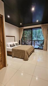 Un dormitorio con una cama y una ventana grande. en Fauna Lodge, en Drake