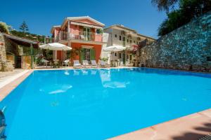 a large blue swimming pool in front of a house at Soustas Apartments in Longós