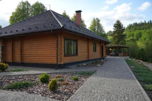 a log cabin with a walkway in front of it at Тіні Предків in Plavie