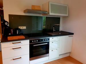 a kitchen with white cabinets and a stove top oven at Ferienwohnung Lug in Lug