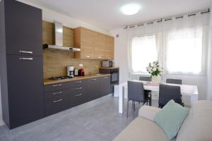 a kitchen and dining room with a table and a couch at Appartamento Business Duplex 95mq - Doppia Terrazza XXL - 2 bagni - Check-in Codice in Padova