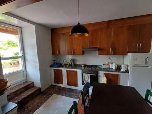 a kitchen with wooden cabinets and a table and a window at Casa descanso en familia junto a la playa y rio in Rianjo