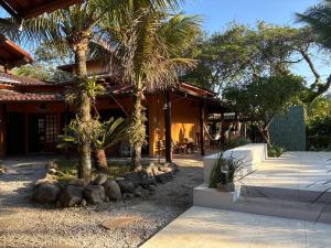 una casa con palmeras delante en Itamambuca Suites, en Ubatuba