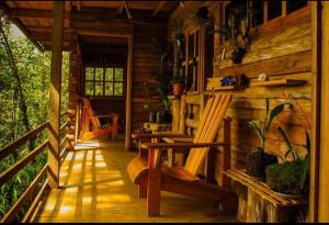 a porch of a log cabin with two rocking chairs at Paraiso Verde in Chijoú
