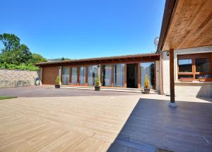 a large building with a wooden floor and a patio at GALIHOST - Chalet con piscina en Vilagarcía de Arousa in Vilagarcia de Arousa