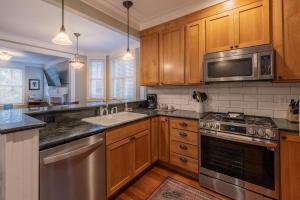 una cucina con armadietti in legno ed elettrodomestici in acciaio inossidabile di Coyote Cottage by Seabrook Hospitality a Pacific Beach