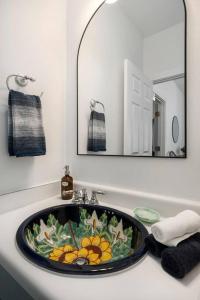 een badkamer met een wastafel en een grote spiegel bij Revins Haus - Fire Pit & Walk to Main St in Fredericksburg +36 foto's