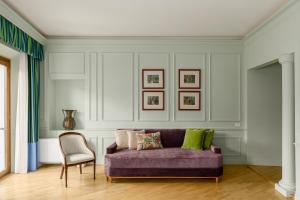 a living room with a purple couch and a chair at Room Mate Collection Isabella, Florence in Florence