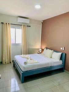 a large bed in a room with a window at La-Villa-m Douala in Douala